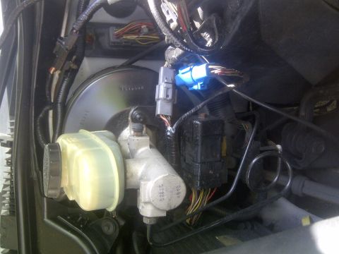 2000 Ford Crown Victoria - Close-up view of the brake master cylinder and associated wiring harness, including a blue electrical connector.