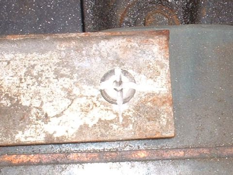 1986 Ford Bronco - Close-up of a rusted metal plate with a screw.