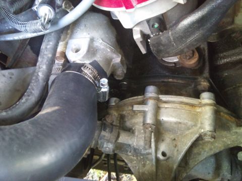1994 Ford Bronco - Engine part detail showing a hose connection and metal housing.