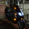 2008 Yamaha Zuma - A dark blue scooter is shown from the front with its lights on.