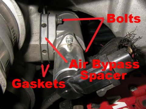 1990 Ford Bronco - Close-up view of an engine component labeled 'Air Bypass Spacer', 'Gaskets', and 'Bolts'.