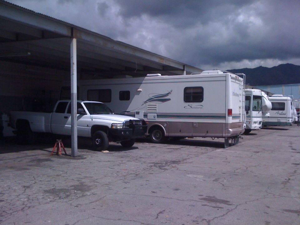 1997 Dodge 3500 pickup truck parked under a carport, with several RVs lined up behind it