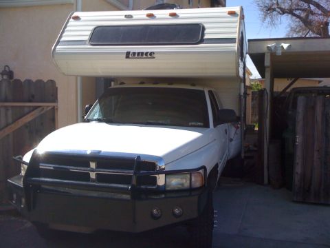 Front view of a white 1997 Dodge 3500 pickup truck with a Lance camper shell