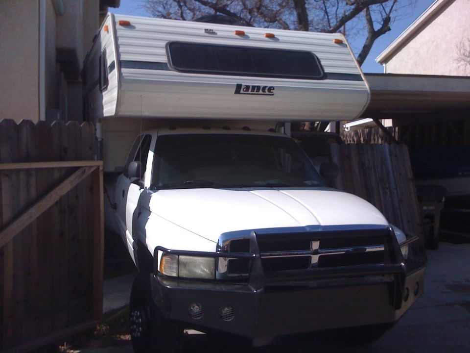 1997 Dodge 3500 pickup truck with a Lance camper shell mounted on top, front view
