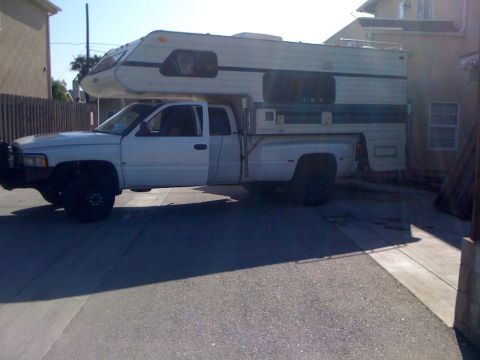 1997 Dodge 3500 - This 1997 Dodge 3500 pickup truck is equipped with a camper shell, seen from the side.