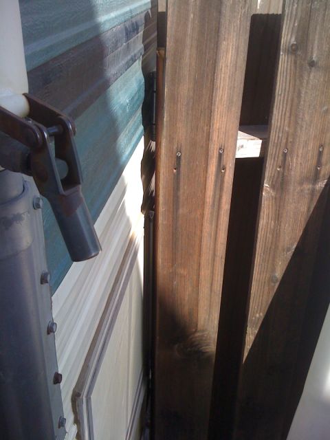 1997 Dodge 3500 - A camper trailer's side panel is visible next to a wooden support beam.