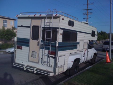 1997 Dodge 3500 - This 1997 Dodge 3500 dually pickup truck is equipped with a Lance camper, viewed from the rear.