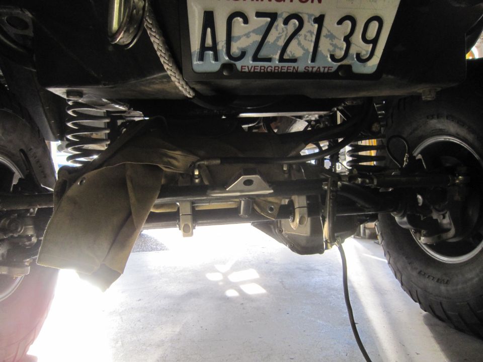 Undercarriage of a vehicle showing suspension, a winch cable, and a Washington license plate reading ACZ2139
