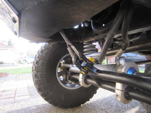 1974 Ford Bronco - Undercarriage view of a modified off-road vehicle's suspension system and winch cable.