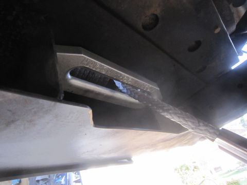 1974 Ford Bronco - A metal shackle mount with a braided rope is attached to the undercarriage of a vehicle.