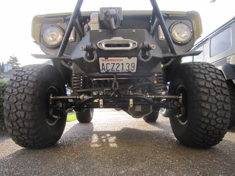 1974 Ford Bronco - A heavily modified off-road vehicle is shown from the front, with a winch mounted on its bumper.