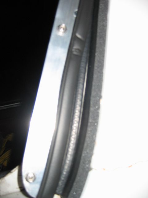 1992 Ford Bronco - Close-up view of a vehicle's door seal and metal frame, showing rivets.