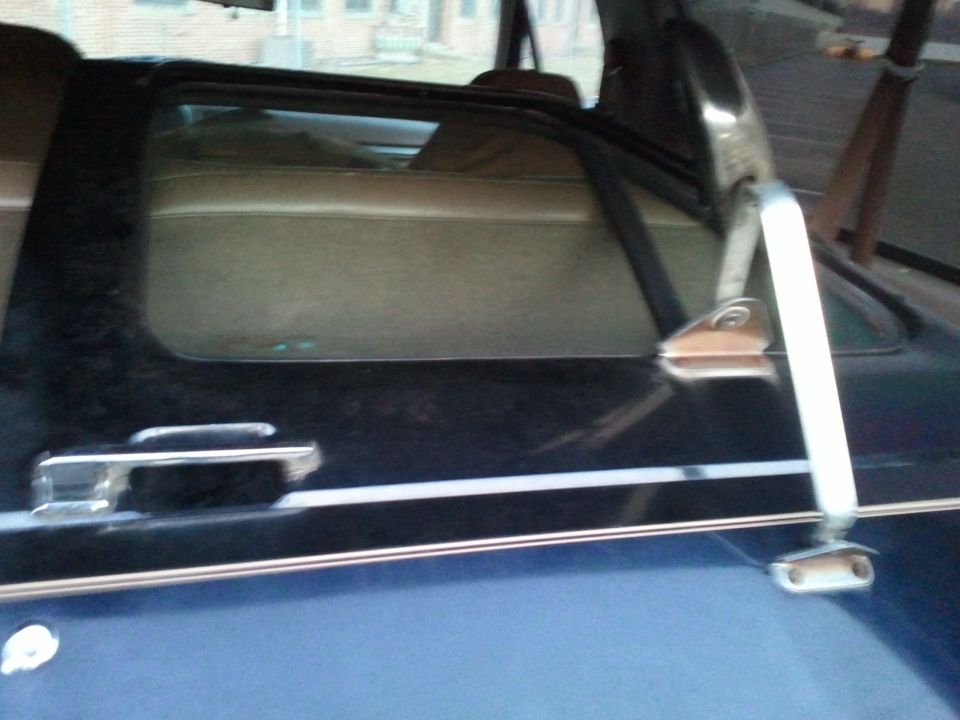 Interior shot of a dark blue SUV, showing the rear passenger seat and window frame