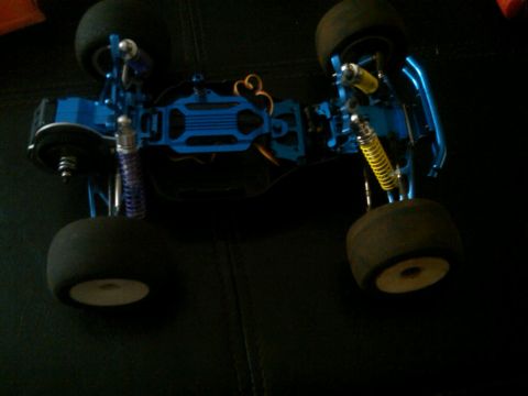 1986 Ford Bronco - Chassis of a blue remote control car, showing suspension and drive components.