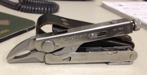 2000 Ford Crown Victoria - Leatherman multi-tool shown with pliers deployed and in its leather sheath.