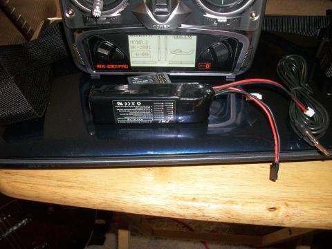 1996 Ford Bronco - A remote control transmitter and its associated battery pack are displayed on a dark surface.