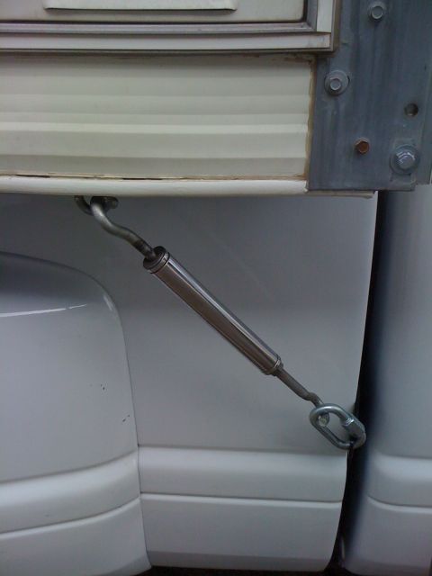 1986 Yugo GV - Turnbuckle used to hold down a door on a white RV or trailer.