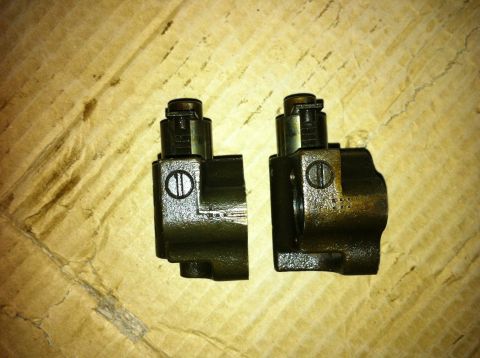 1998 Ford Crown Victoria - Pair of automotive timing chain tensioners shown on a surface.