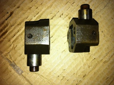 1998 Ford Crown Victoria - These engine parts, possibly timing chain tensioners, are shown up close on a textured surface.