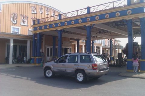 1991 Ford Crown Victoria - A Jeep Grand Cherokee is parked in front of a hotel with a Western-themed facade.