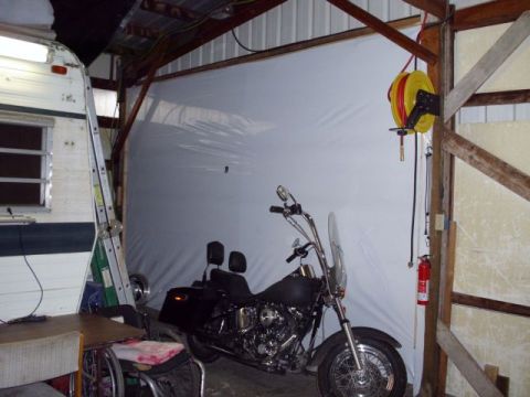 1989 Ford Bronco - Motorcycle is parked in a garage with a trailer and a wheelchair nearby.