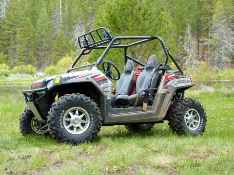1970 Ford Bronco - Side-by-side ATV with roll cage and racing seats is parked outdoors in a natural setting.