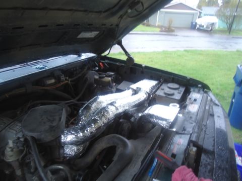 1995 Ford Bronco - The engine bay of a vehicle, showing modified intake tubes and a visible watermark.