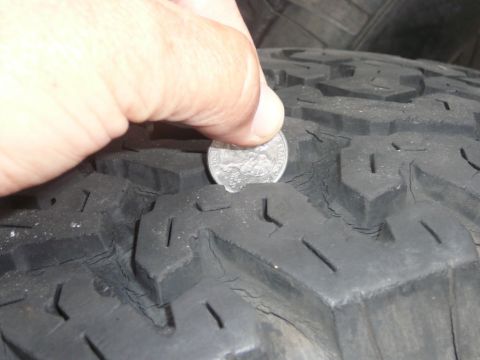 1988 Ford Bronco - Checking tire tread depth with a quarter coin.