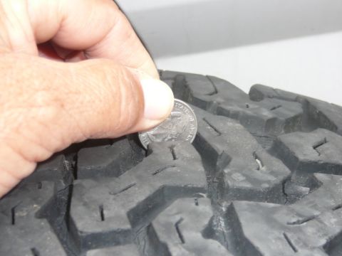 1988 Ford Bronco - Checking tire tread depth with a quarter.