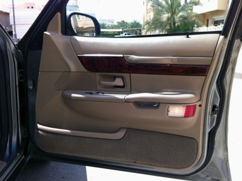 2001 Mercury Grand Marquis - The interior door panel of a car, showing the door handle, window controls, and a courtesy light.