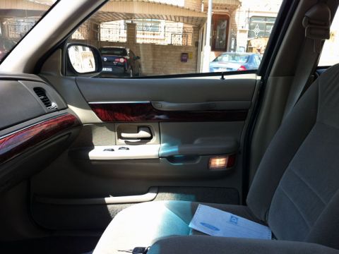2001 Mercury Grand Marquis - The interior door panel features wood trim and a courtesy lamp, consistent with a 2001 Mercury Grand Marquis.