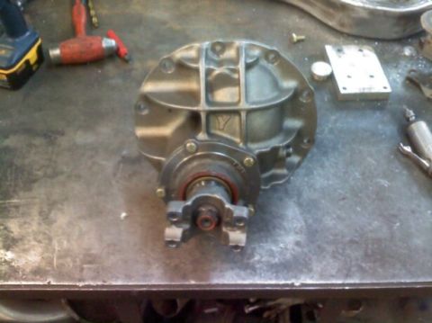 1988 Ford Bronco - Differential housing part on a workbench with tools nearby.