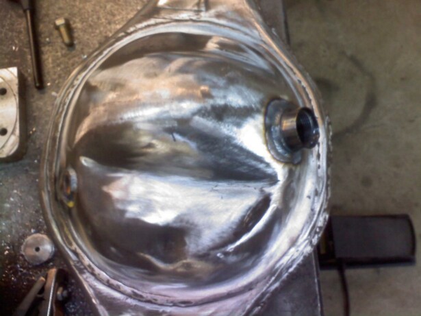 Close-up of a shiny metal differential housing with a pipe fitting attached