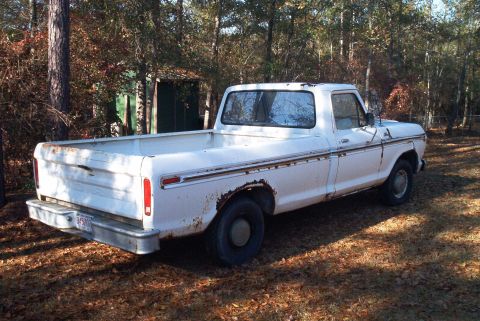 1992 Ford Bronco - This white pickup truck, likely from the 1970s, is parked outdoors with trees in the background.