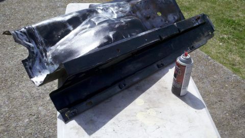1978 Ford Bronco - Automotive part and spray can on a table, likely for restoration or repair.