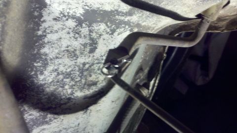 1978 Ford Bronco - Underbody view of an exhaust pipe connection being worked on.