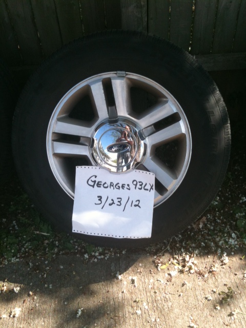 1993 Ford Crown Victoria - A single Ford wheel is shown, with a handwritten note attached to the spokes.
