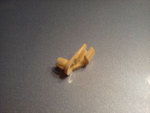 1996 Ford Bronco - A tan plastic clip, likely for a throttle cable, is shown against a textured gray background.