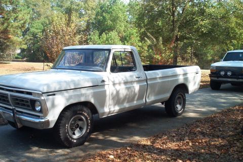 1992 Ford Bronco - White 1977 Ford F-150 pickup truck parked on a driveway with another truck behind it.
