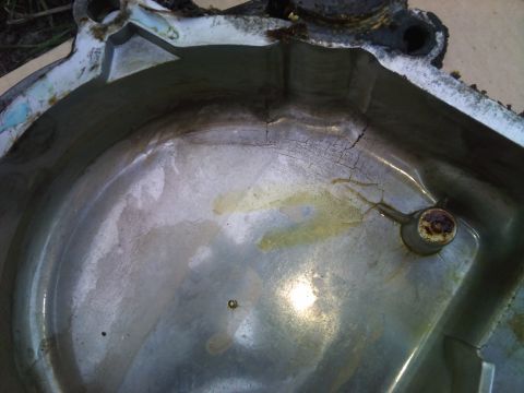 1994 Ford Bronco - This cracked metal part shows signs of oil residue and damage.
