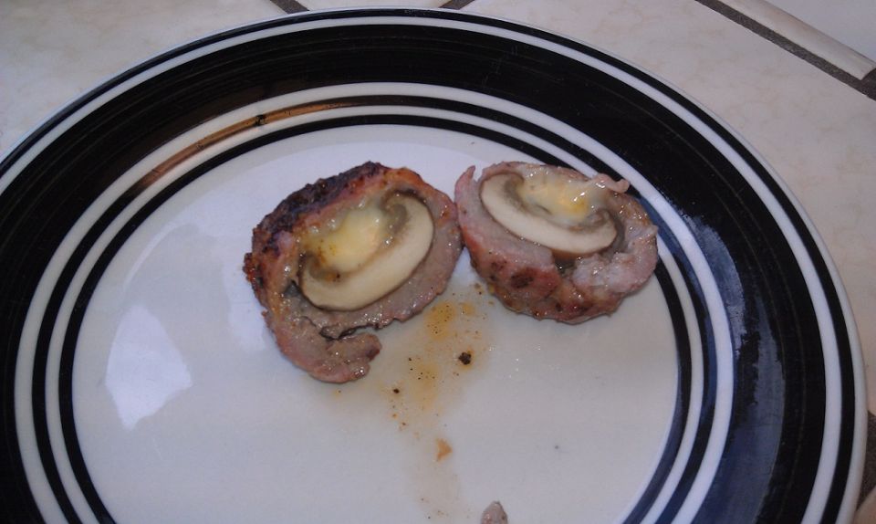 Two halves of a meat and mushroom dish on a plate