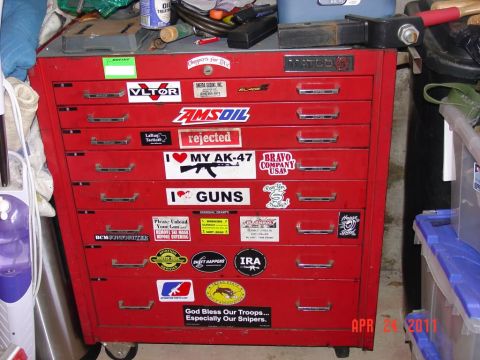 2000 Ford Crown Victoria - Red Matco tool chest covered in stickers, including gun and military-themed decals.
