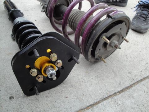 1995 Ford Taurus - Coilover suspension parts are shown laid out on a concrete surface.