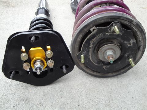1995 Ford Taurus - Pair of aftermarket coilovers, one with a gold adjustable mount and the other showing a purple spring and mounting plate.