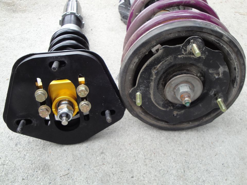 Aftermarket coilovers with gold adjustable mounts and purple springs