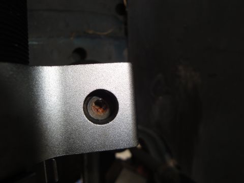 1995 Ford Taurus - A close-up view of a metal bracket and a rusty bolt, likely a part of a vehicle's suspension system.