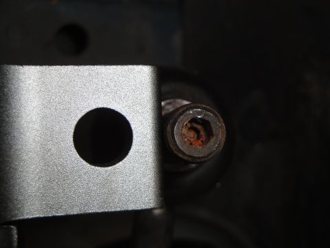 1995 Ford Taurus - A close-up view of a rusted hex bolt head and a metal bracket, indicating a mechanical component.