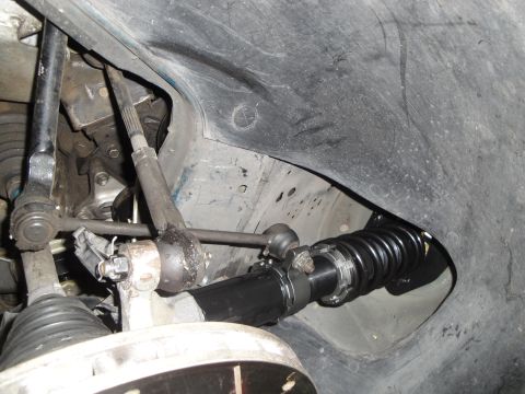 1995 Ford Taurus - Close-up view of a black coilover suspension component installed in the wheel well of a vehicle.