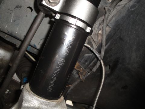 1995 Ford Taurus - A close-up view of a car's suspension component, identified as "SHO SOURCE".