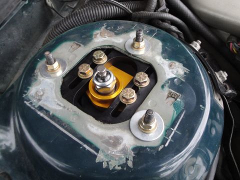 1995 Ford Taurus - Close-up of a vehicle's engine bay, focusing on the strut mount and adjustable coilover assembly.